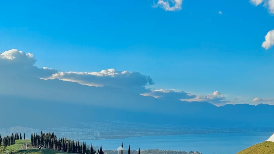 Rolling green hills overlooking the sparkling waters of Erhai Lake in Dali Yunnan