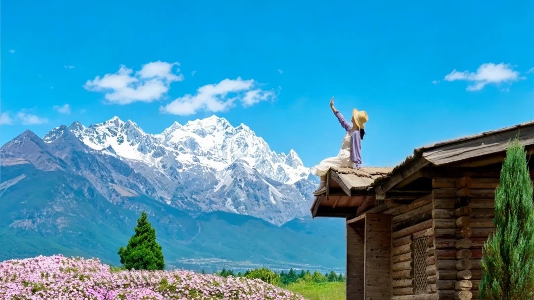 Authentic timber cabin, blooming flowers, and Jade Dragon Snow Mountain reflection in Lijiang